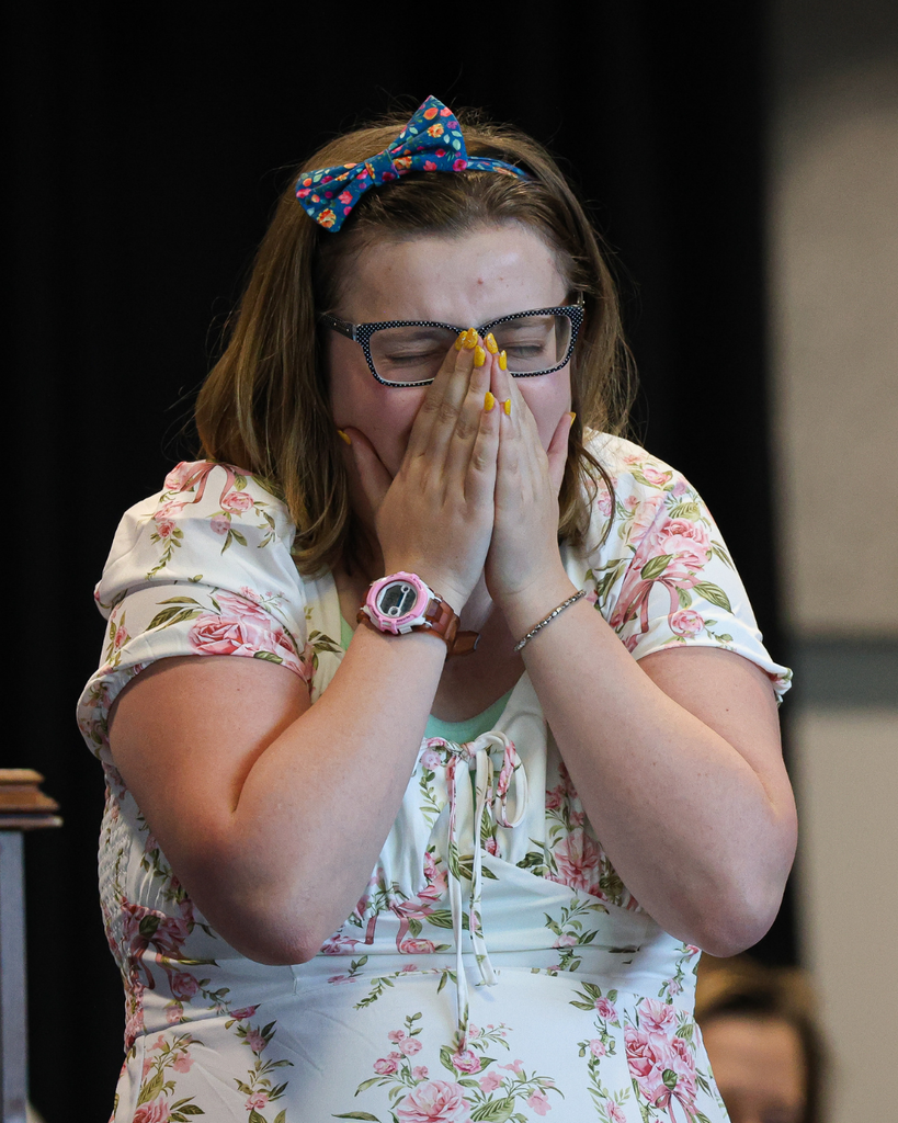 A Vista Education Campus graduate puts her hands to her face as she is full of emotion. 