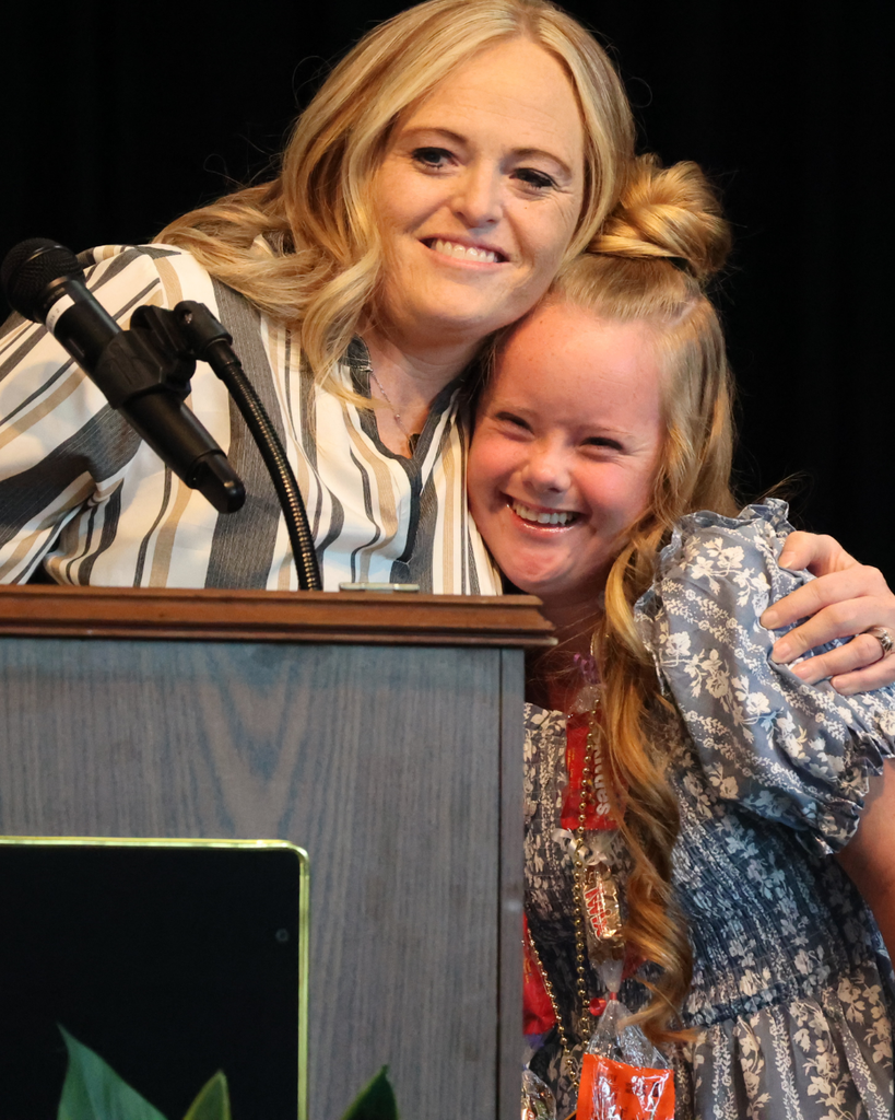 A Vista Education Campus graduate hugs her teacher. 