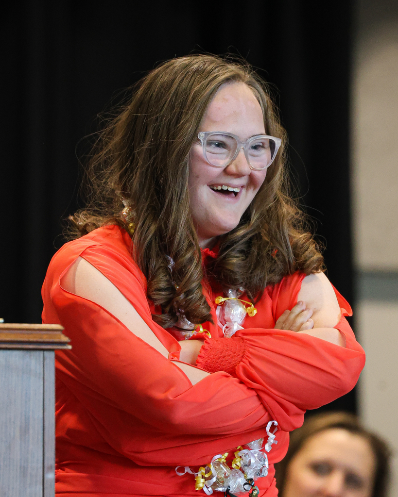 A Vista Education Campus graduate smiles with her arms folded. 
