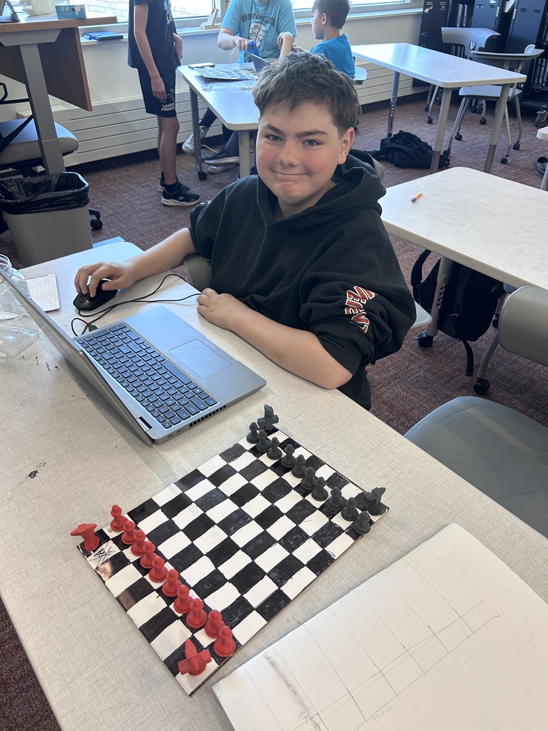 Student poses with his game board.