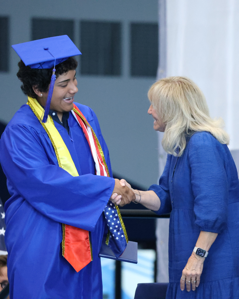 A Mountain High graduate shakes the hand of Board President Brigit Gerrard.