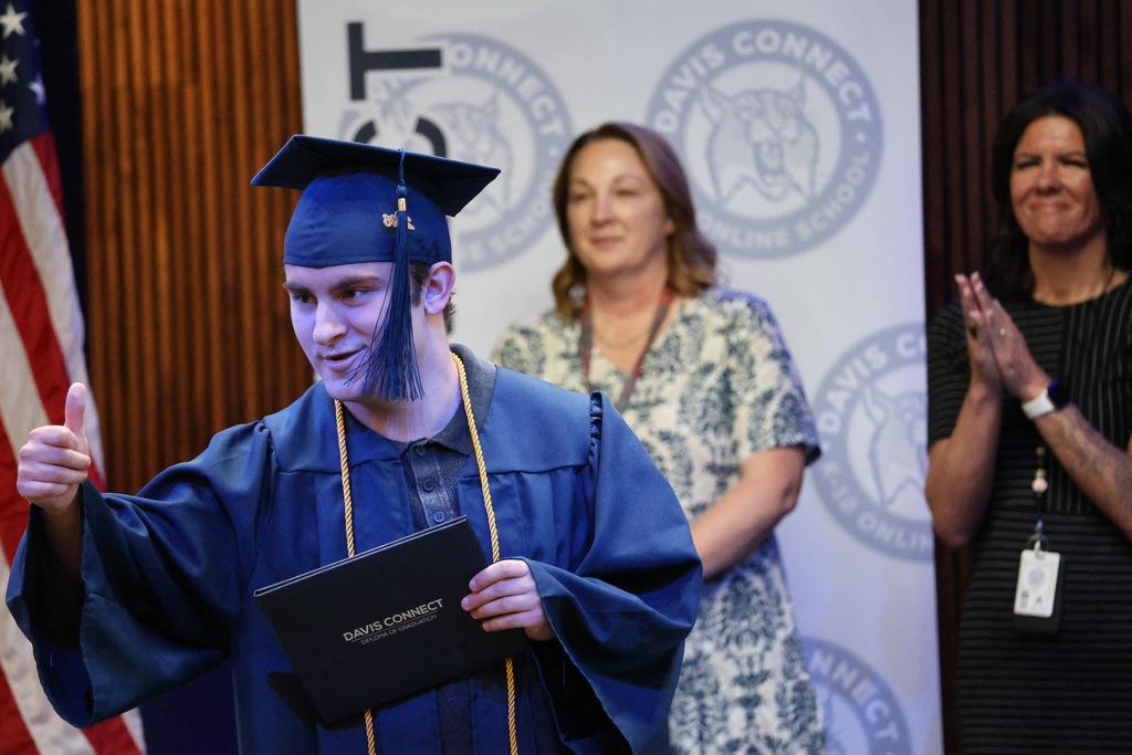 A Davis Connect graduate giving the audience a thumbs up. 