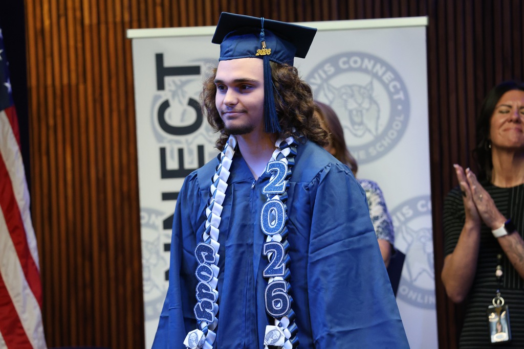 A Davis Connect graduate smiling as they walk back to their seat. 
