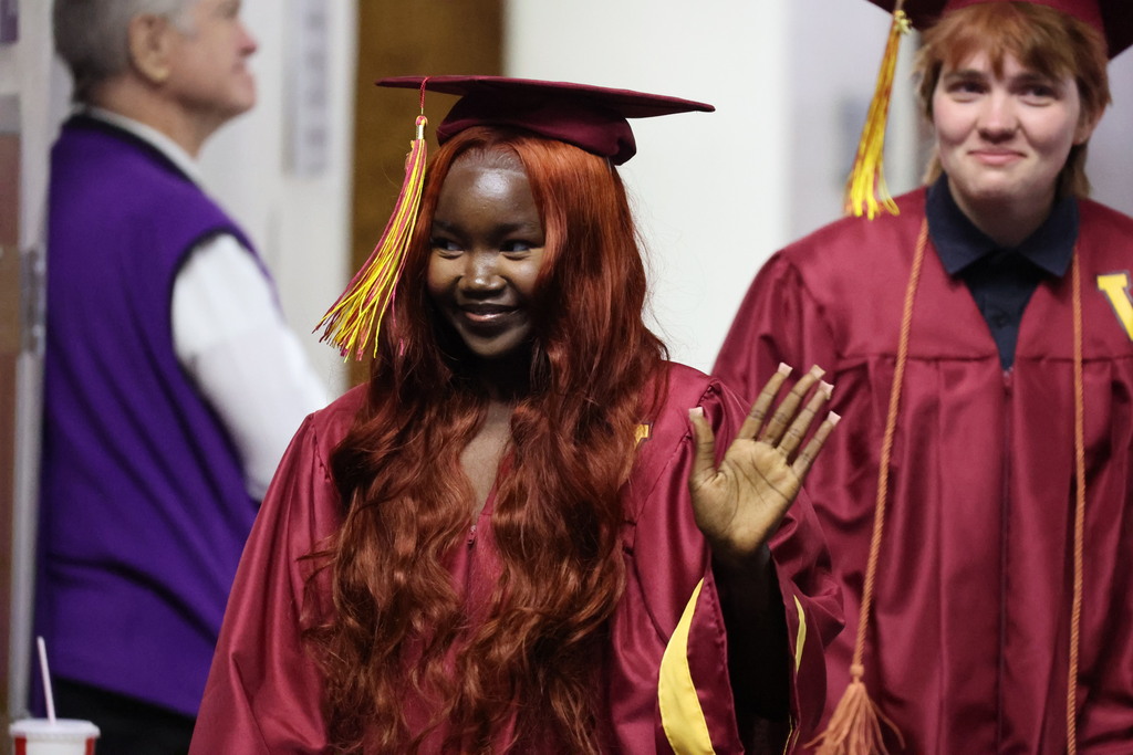 A Viewmont High graduate waves her hand as she walks in. 