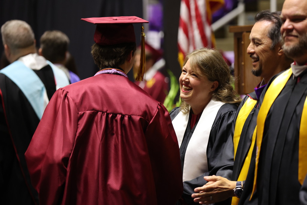 A Viewmont High graduate shakes the hand of board member Alisa Mercer. 