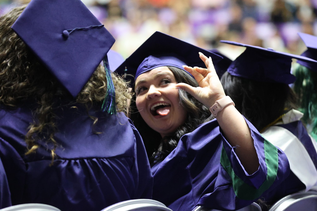 A Syracuse High graduate with a silly face looks to the right.