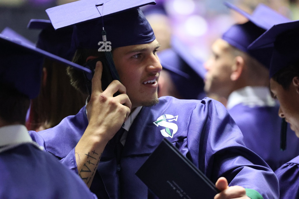 A Syracuse High graduate on the phone looks for someone. 