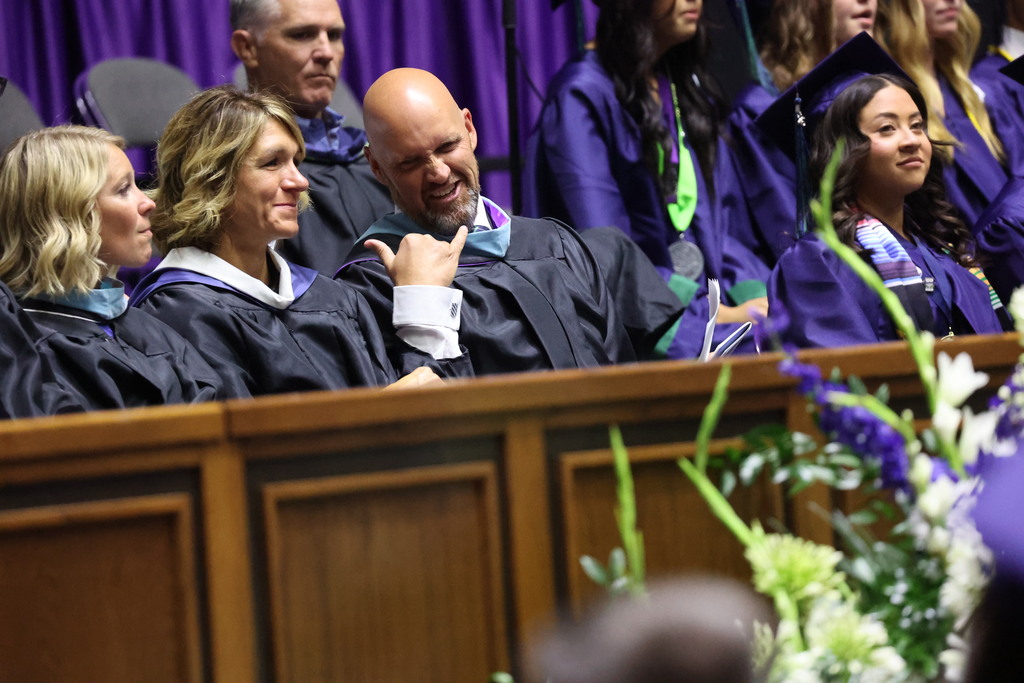 Syracuse administration talking during graduation.