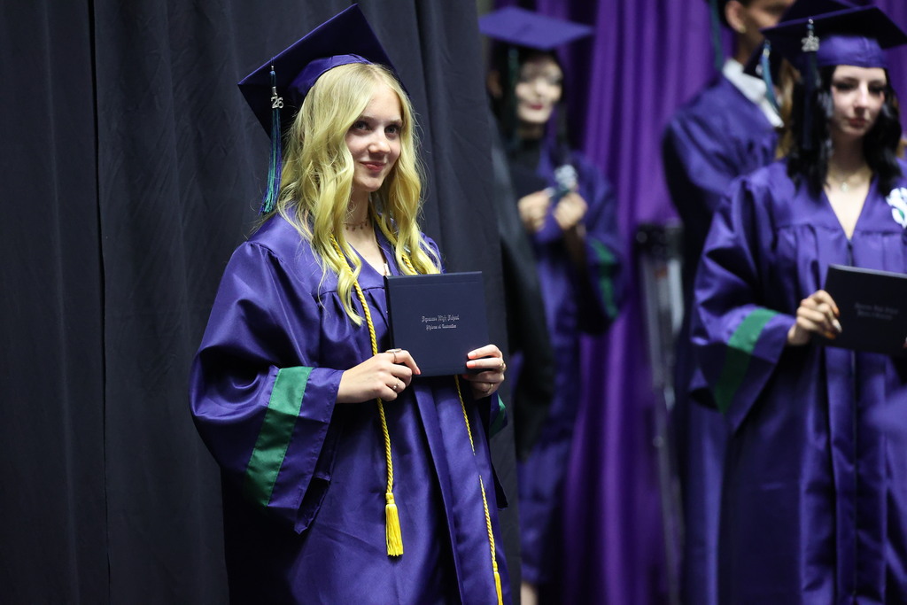 A Syracuse High graduate smiling to the right. 