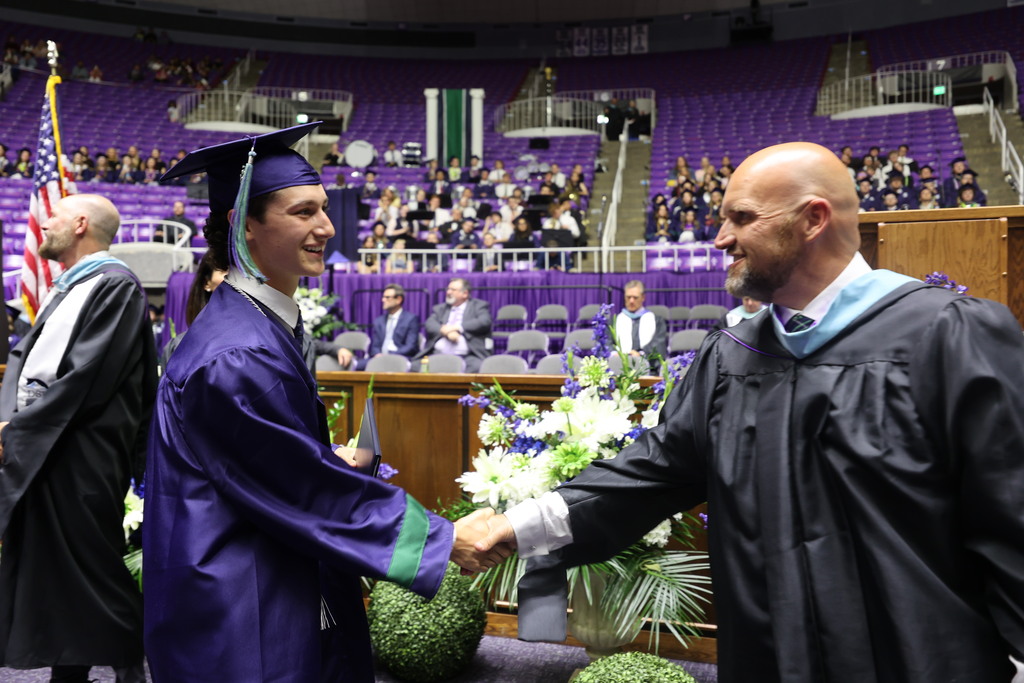 A Syracuse High graduate shakes the hand of Principal Brad Chappel.