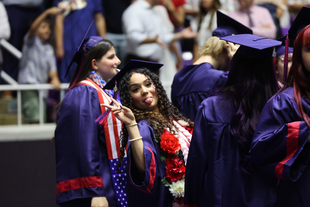 A Woods Cross graduate sticks out their tongue and gives a peace sign.