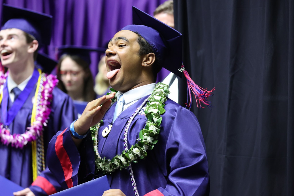 A Woods Cross graduate sticks out his tongue happily.