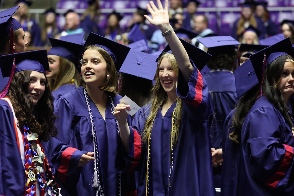 Woods Cross graduates waving into the crowd.