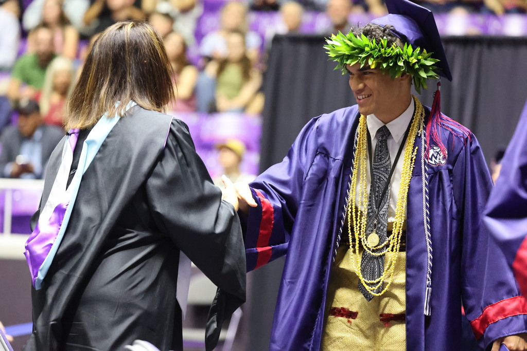 A Woods Cross graduate about to shake hands with their principal, Jo Richins.