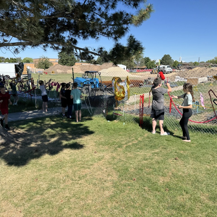 Kids hanging art on the fence  