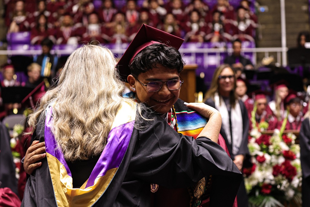 A Northridge High graduate hugs a teacher during graduation.