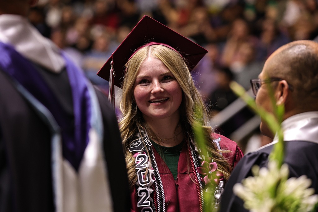 A Northridge High graduate smiles as they shake hands of administrators.