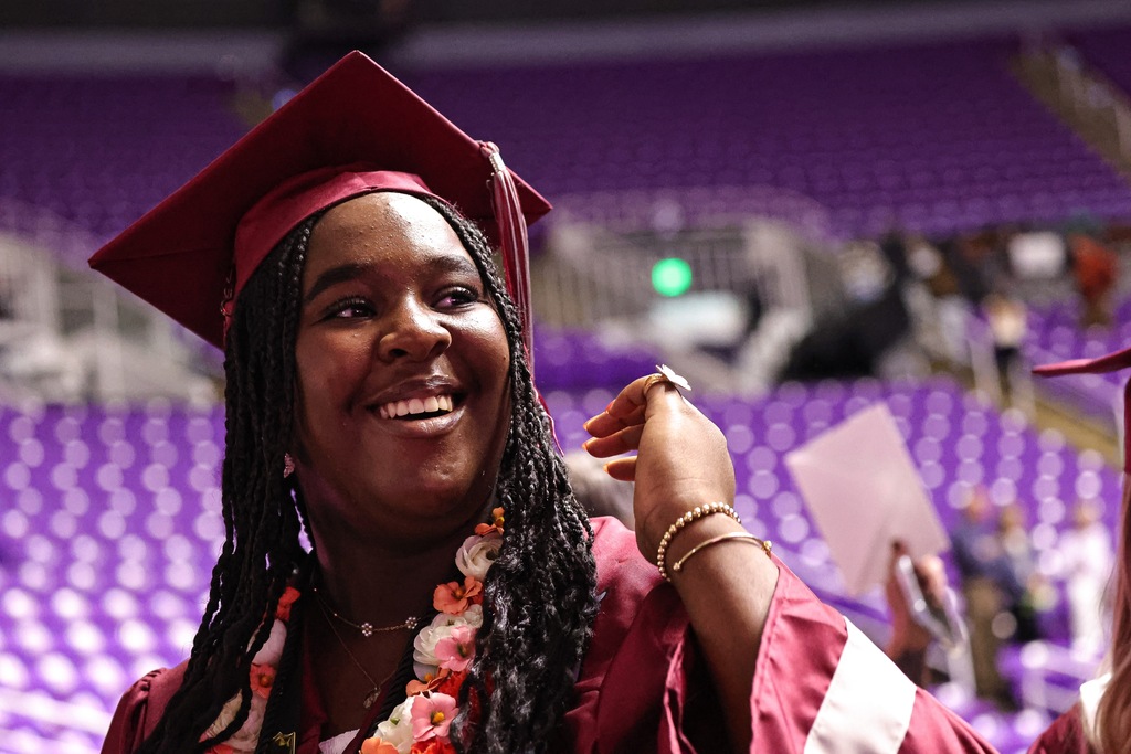 A Northridge High graduate smiles while exiting graduation.