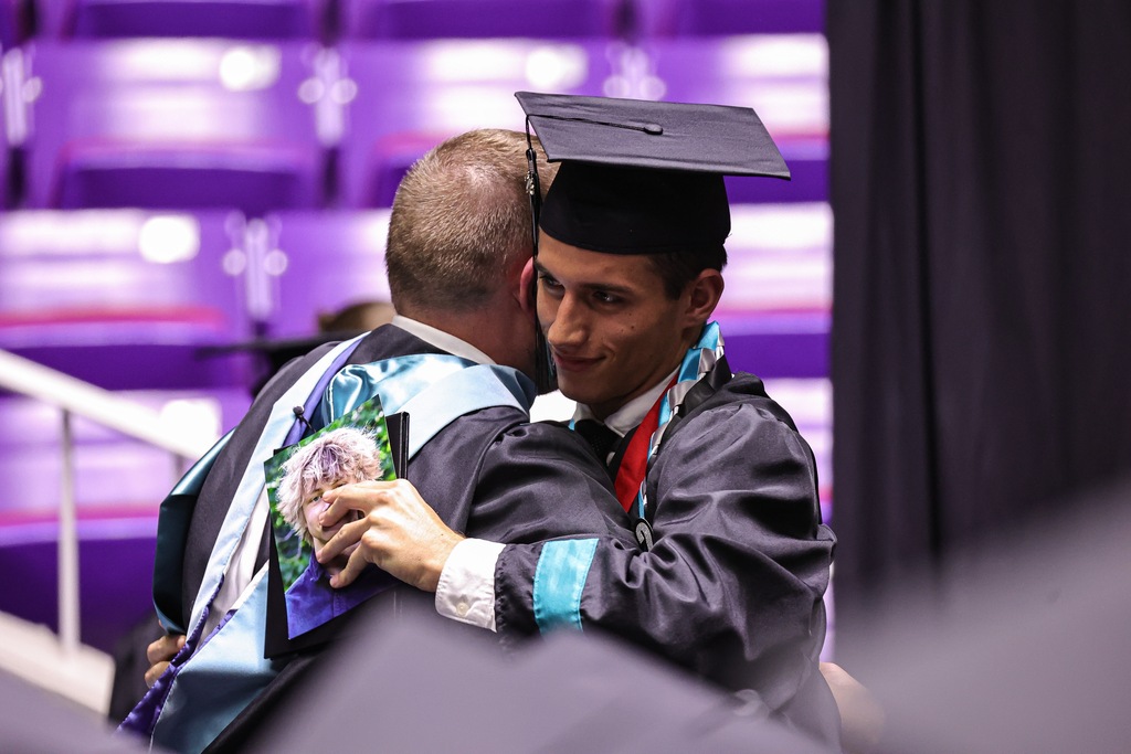 Farmington High graduate hugs a teacher.