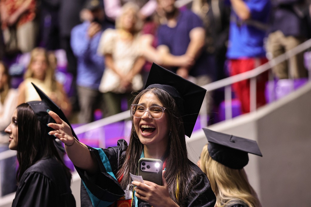 Farmington High graduate holding out her hand in awe. 