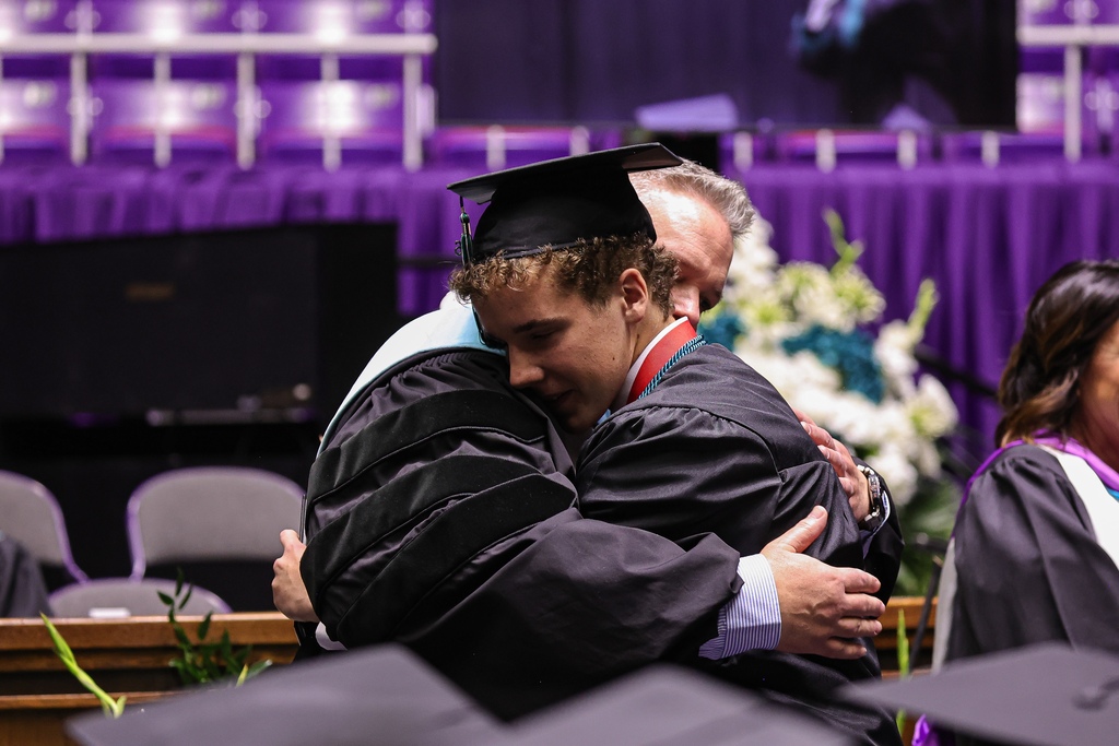 Farmington High graduate hugs an admin.