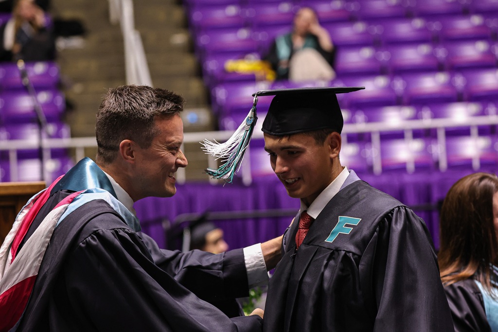 Farmington High graduate shakes hands with principal Justin Whittaker.