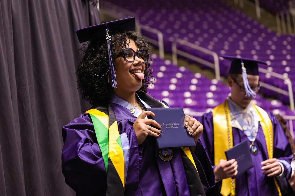 Layton High graduate sticking her tongue out while holding her diploma.