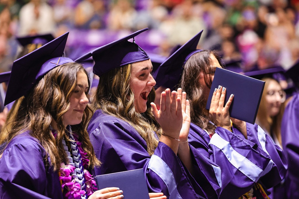 Layton High graduates clapping during graduation.