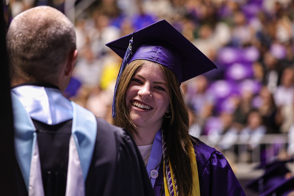 Layton High graduate smiling at the camera while shaking hands.