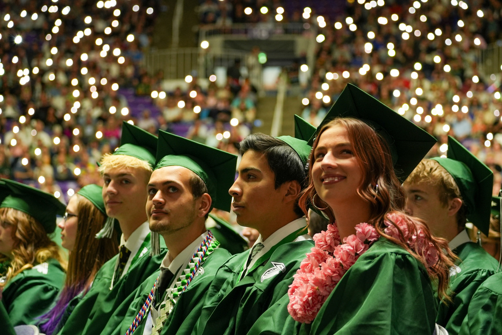 Clearfield High graduates look in awe as the auditorium fills with flashlights from phones.