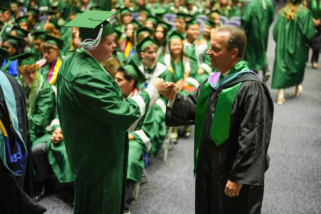 Clearfield High graduate fist bumps principal TJ Barker.