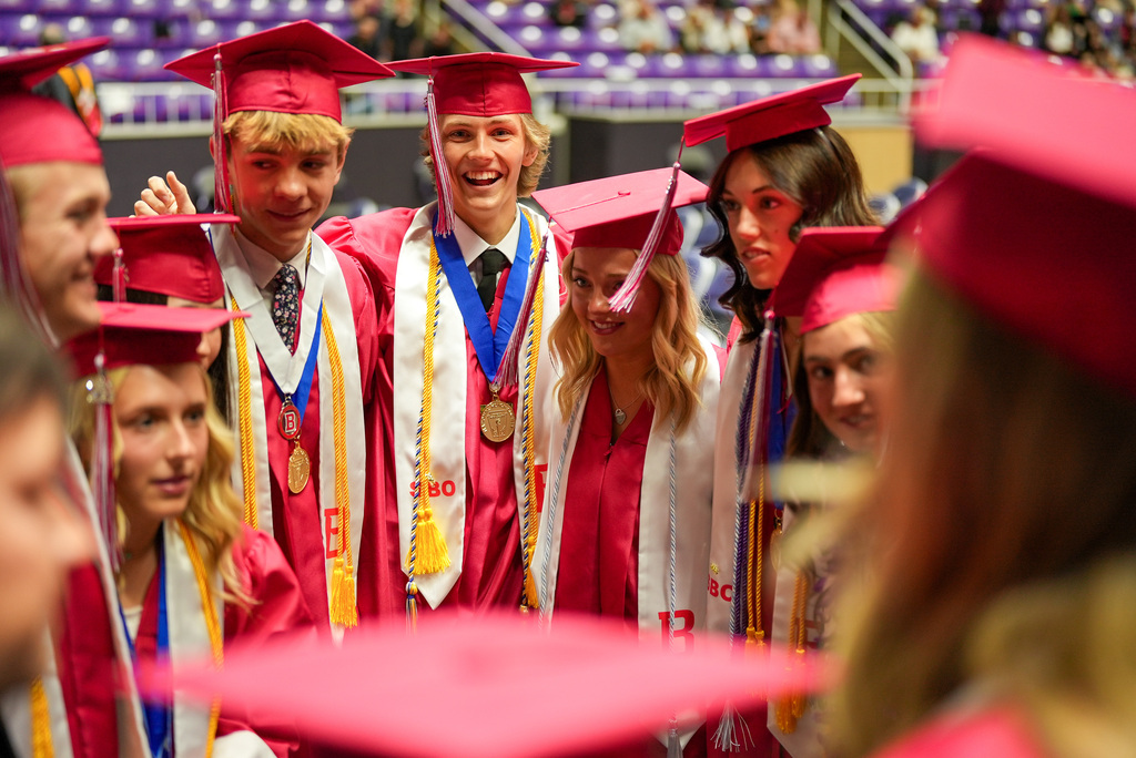 Bountiful High graduates hug each other.