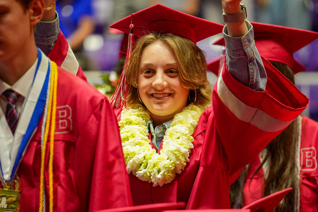 Bountiful High graduate celebrates by putting their arms up. 