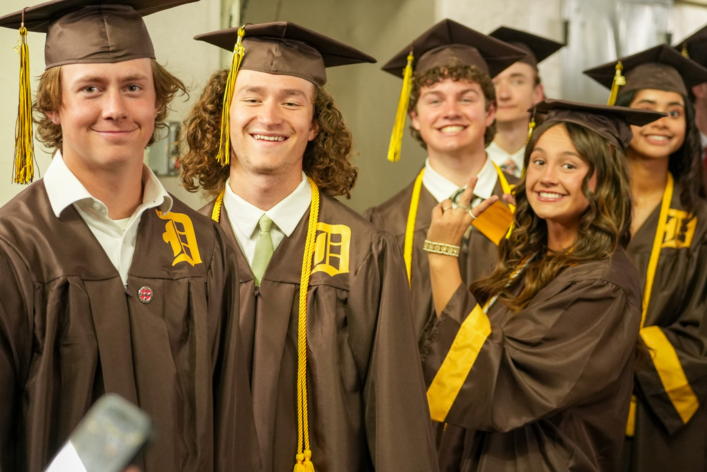 Davis High graduates smiling at the camera while in the tunnel.