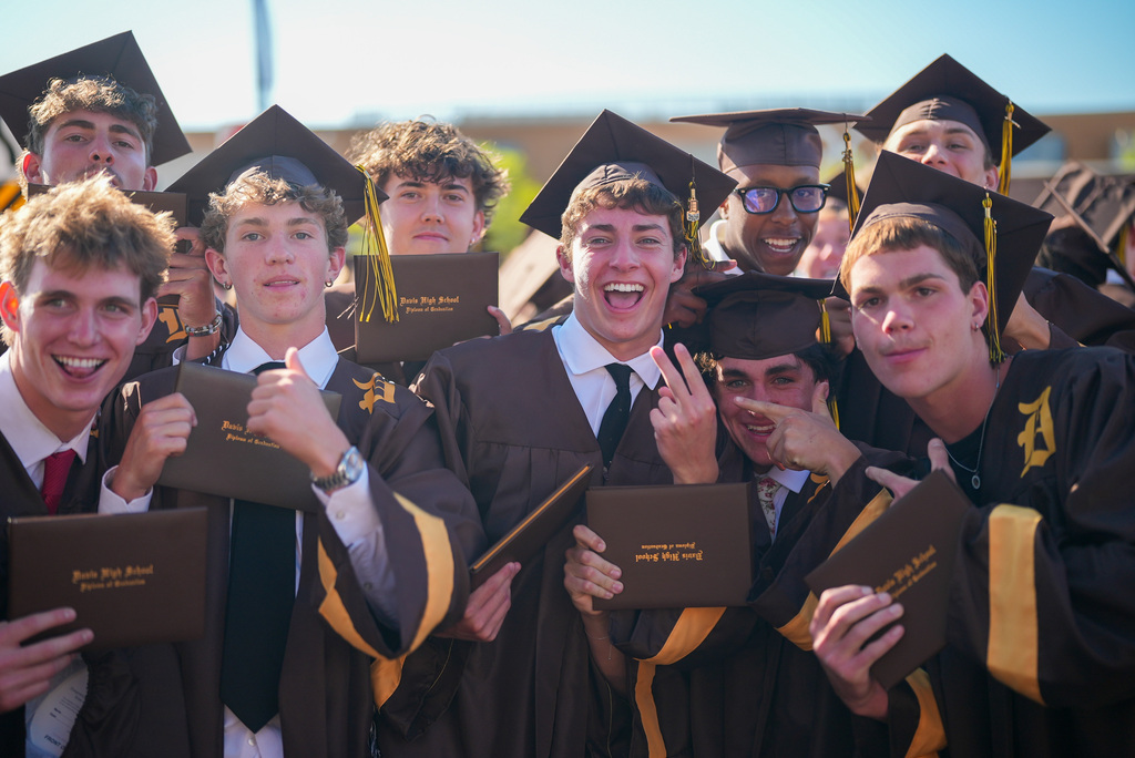 Davis High graduates smiling at the camera.