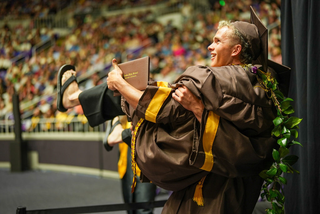 Davis High graduate being held by another Davis High graduate.