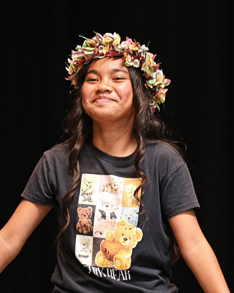 A Foxboro student wearing a flower lei looks happy.