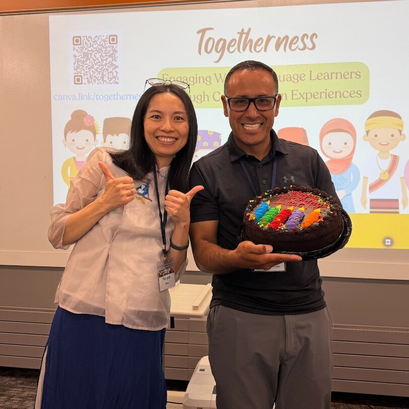 two teachers smiling with a birthday cake