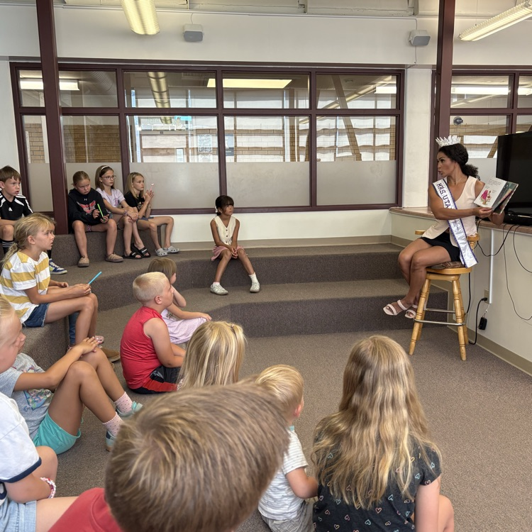 Mrs Utah, 2026 reading a story to students in the library