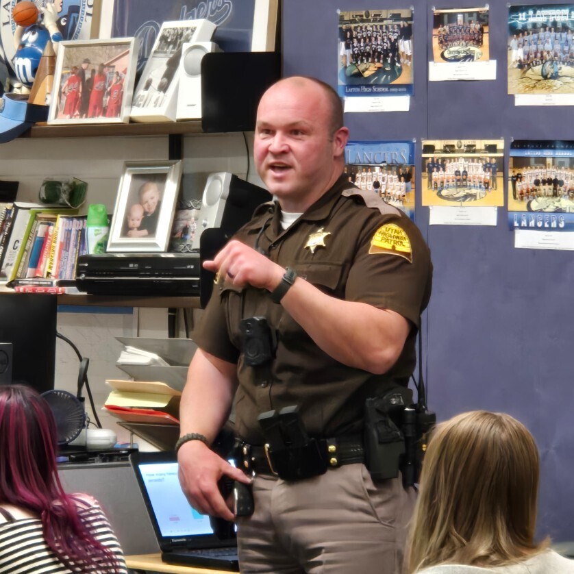 a highway patrolling officer teaches a class of students 