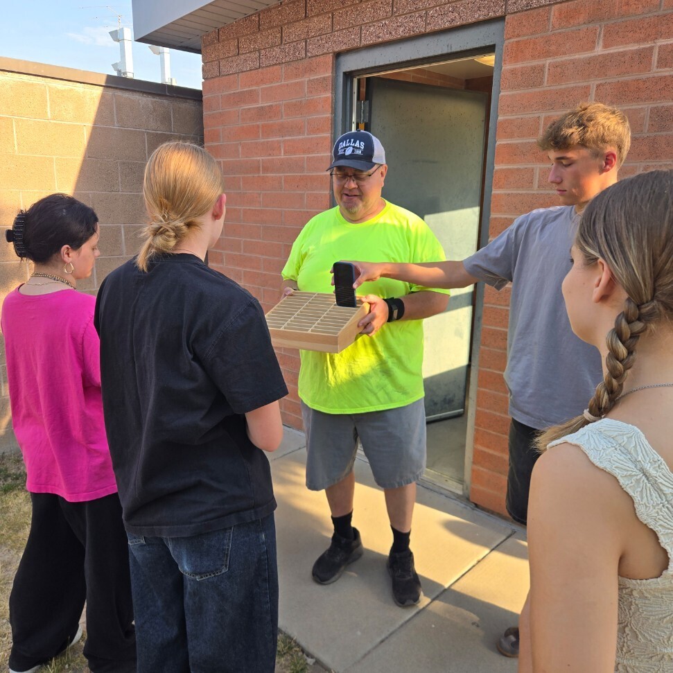 students turning in their phones before driving on the range for the first time