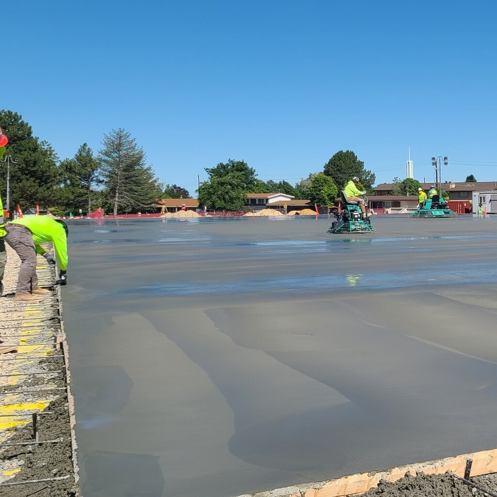final touches by construction workers on brand new concrete gym floor