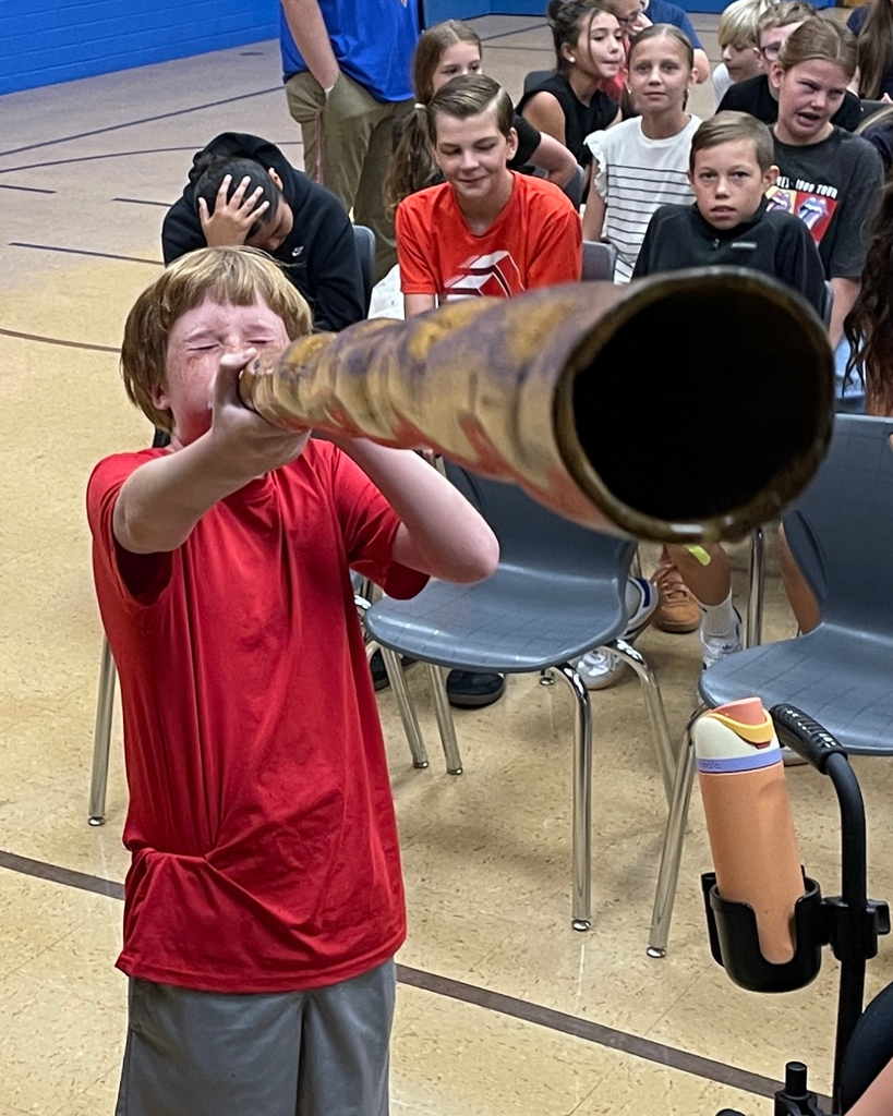 A student blowing into an instrument.