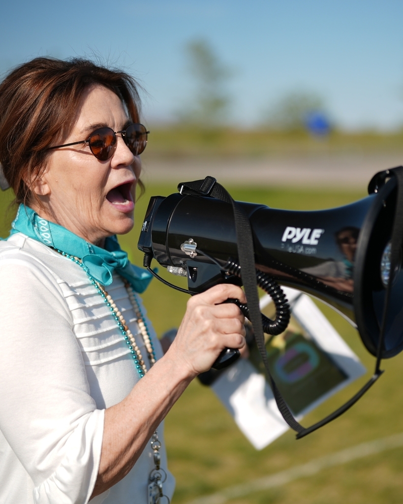 A person talking into a black megaphone.