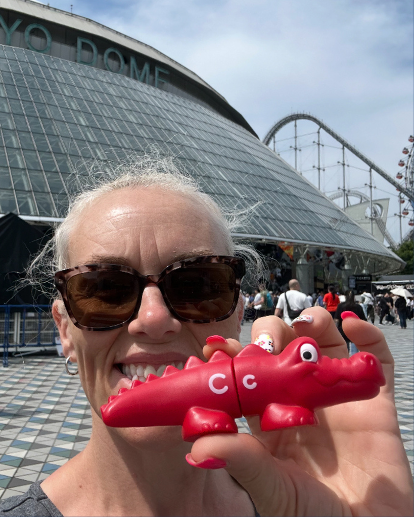 Someone posing with a small crocodile.