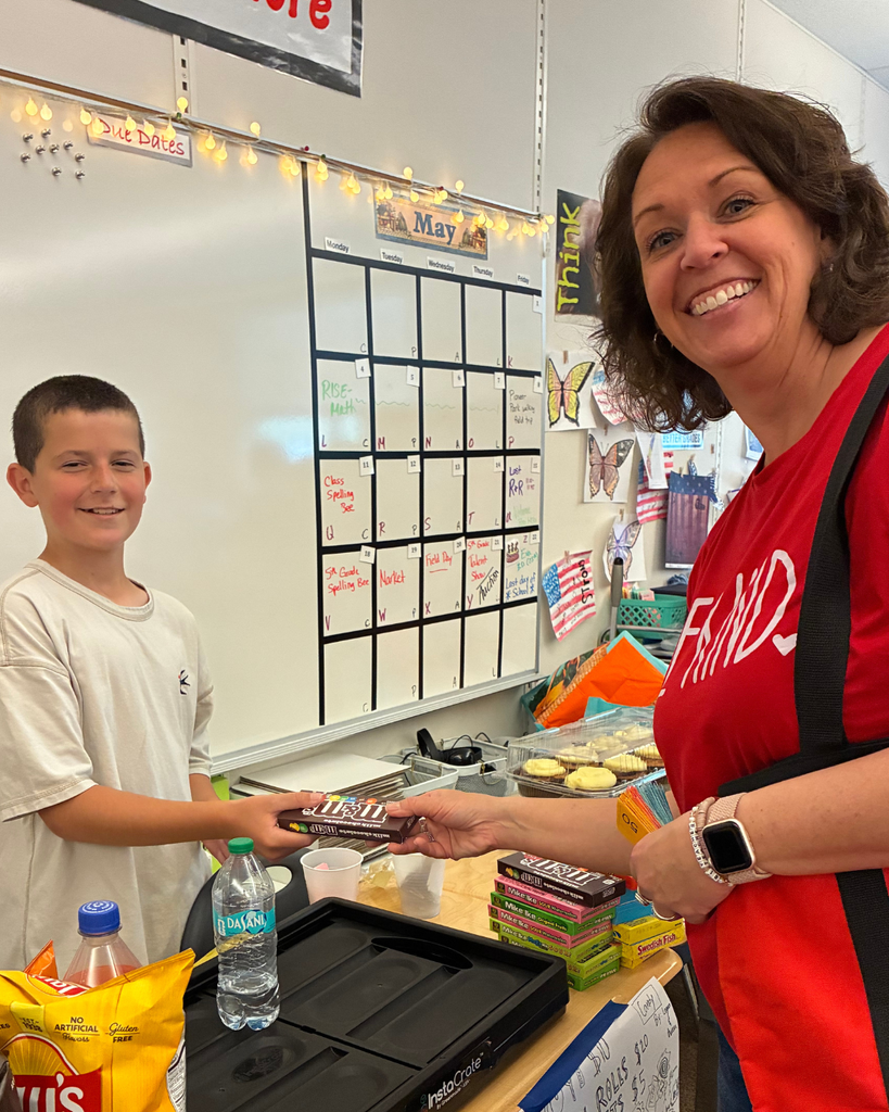 A student handing an adult some candy.