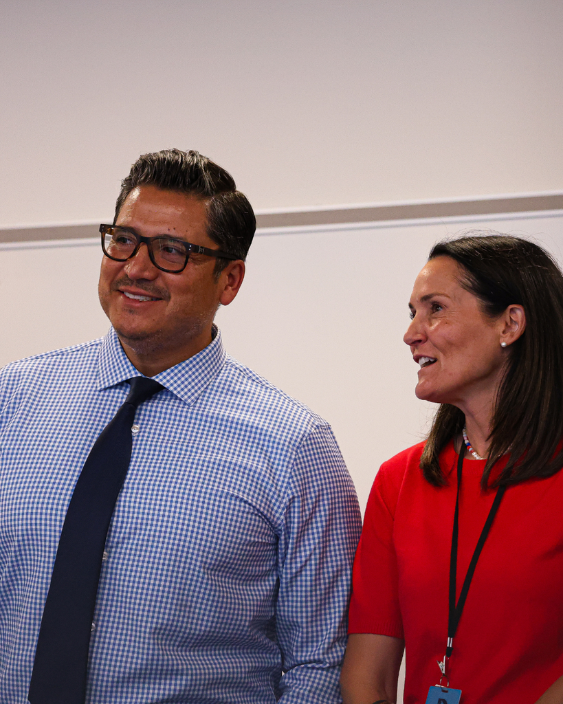 Two people smiling and looking to the left.