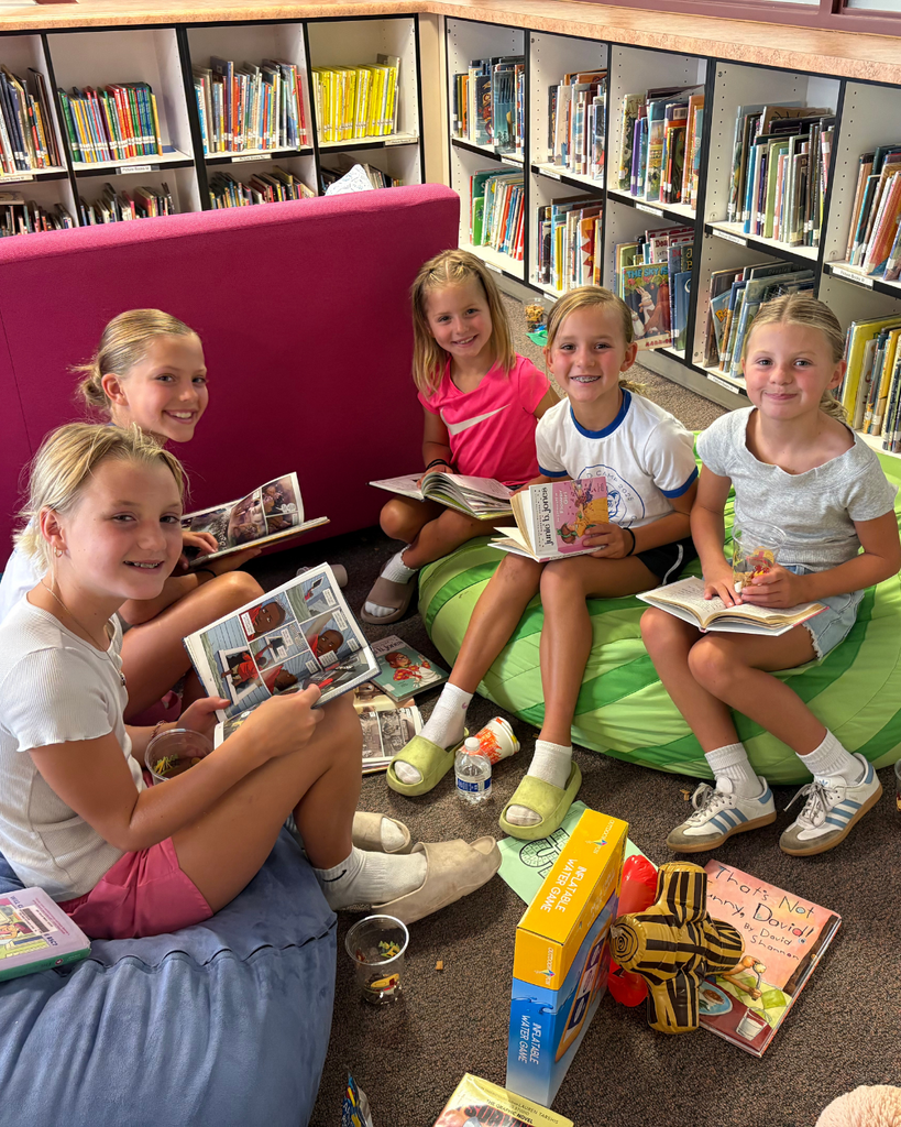 Five students reading on beanbags together.
