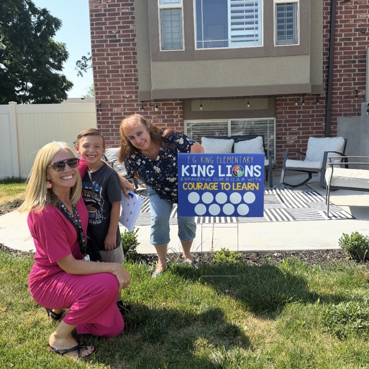 student and a teacher posing with school yard sign 