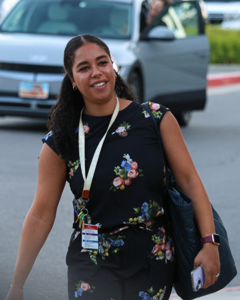 A teacher smiles as she walks into a school.